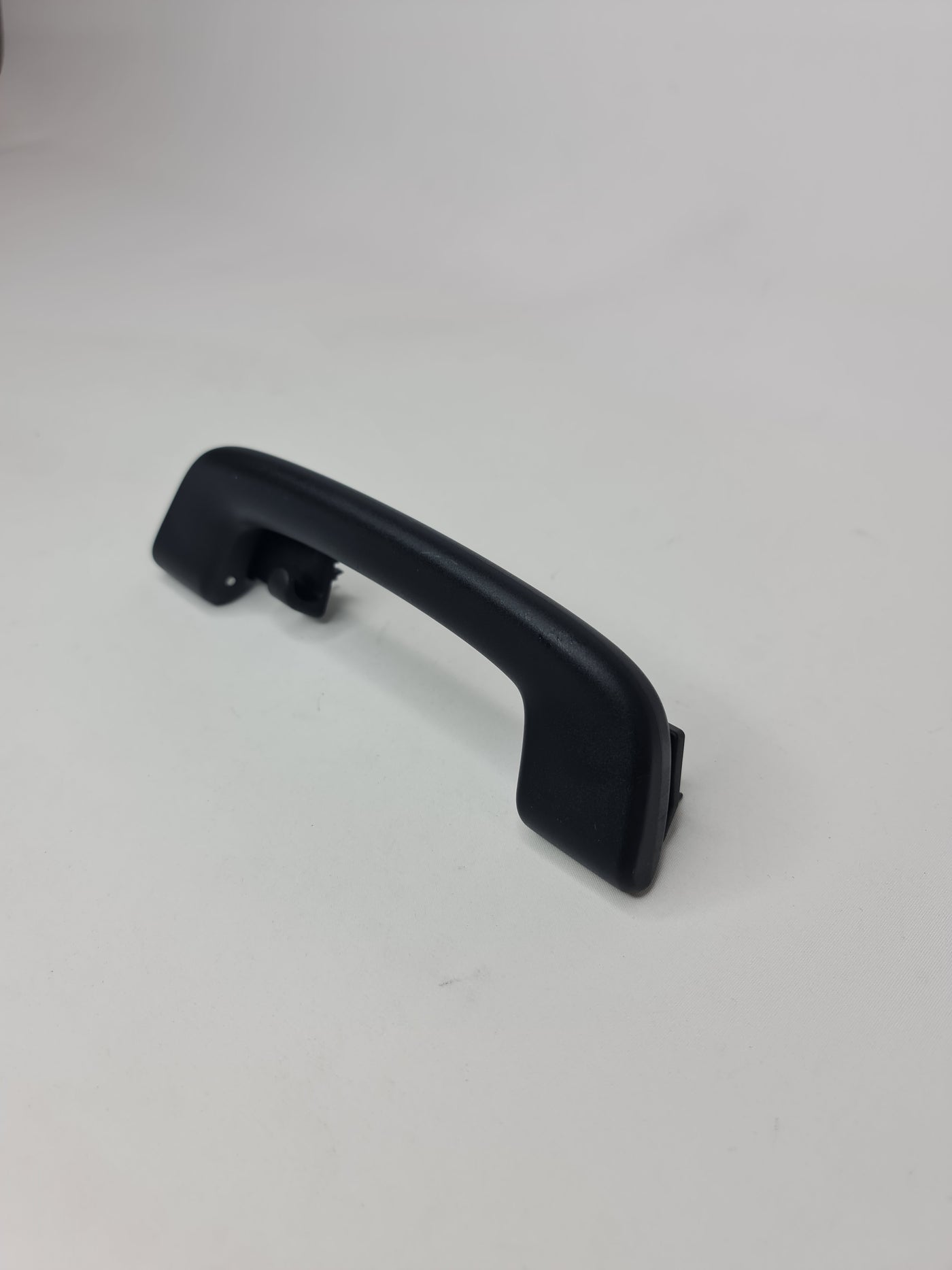 Black F80 roof grab handle arm holder from MPerformance.parts, mounted inside a vehicle for secure support.