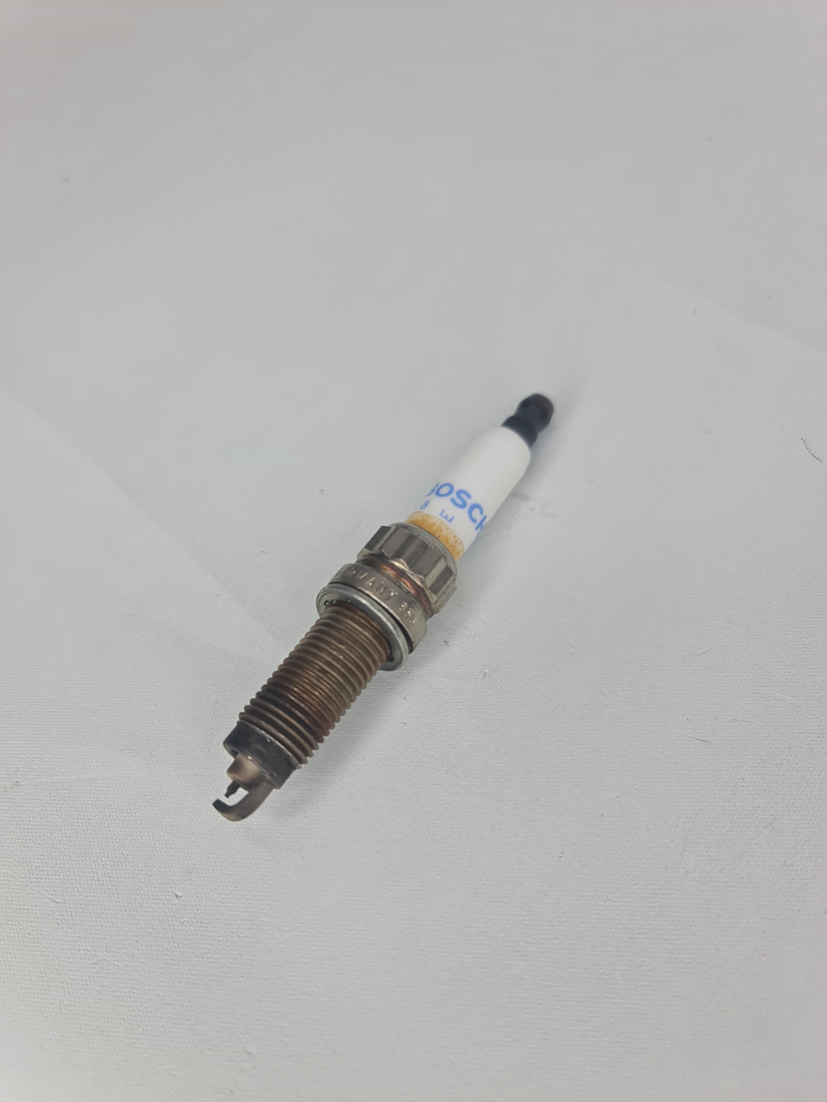 BMW high power spark plug 2012-2016 model, part number 12-12-0-038-832, showing metallic tip and ceramic insulator.