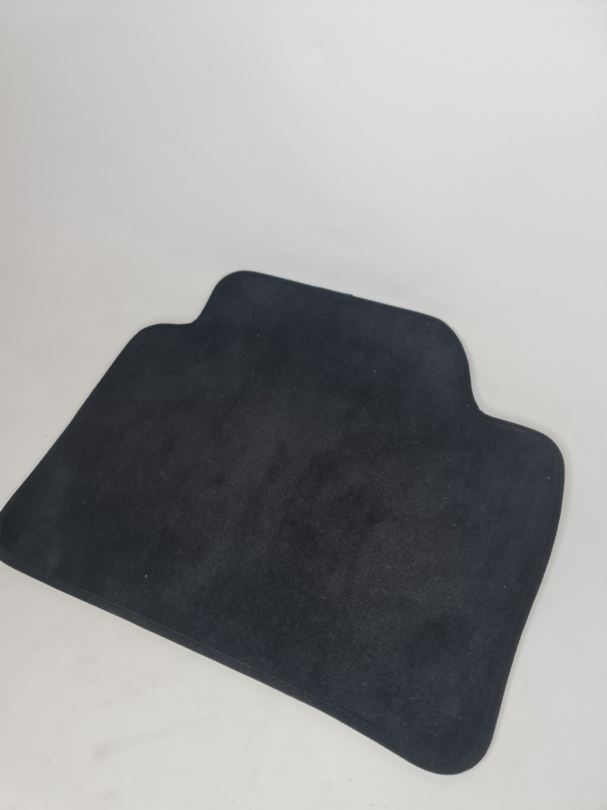 F80 M3 rear right floor mat from MPerformance.parts showing textured black rubber with logo detail.
