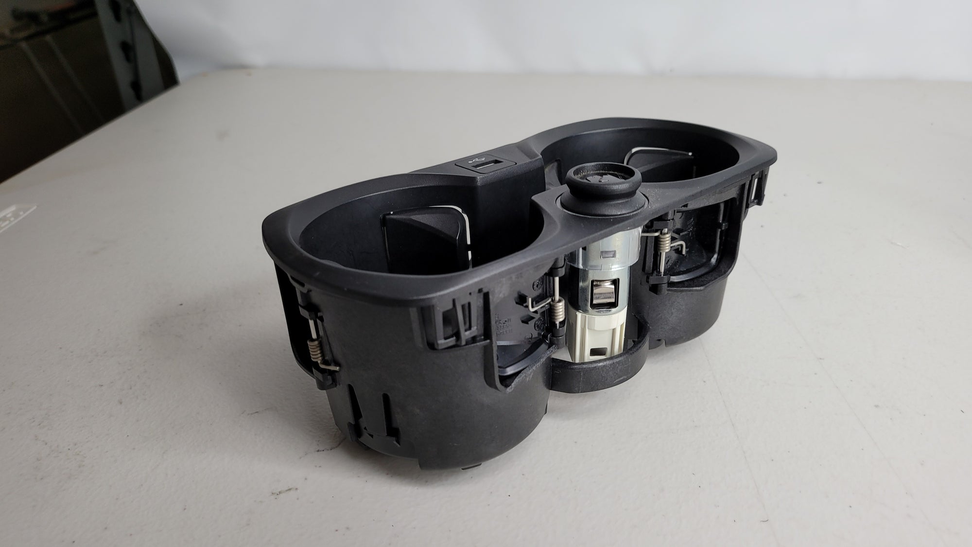 BMW M3 G80/81/82/83 MPerformance.parts center console cup holder with 12V charger and USB plug, mounted in the vehicle interior.
