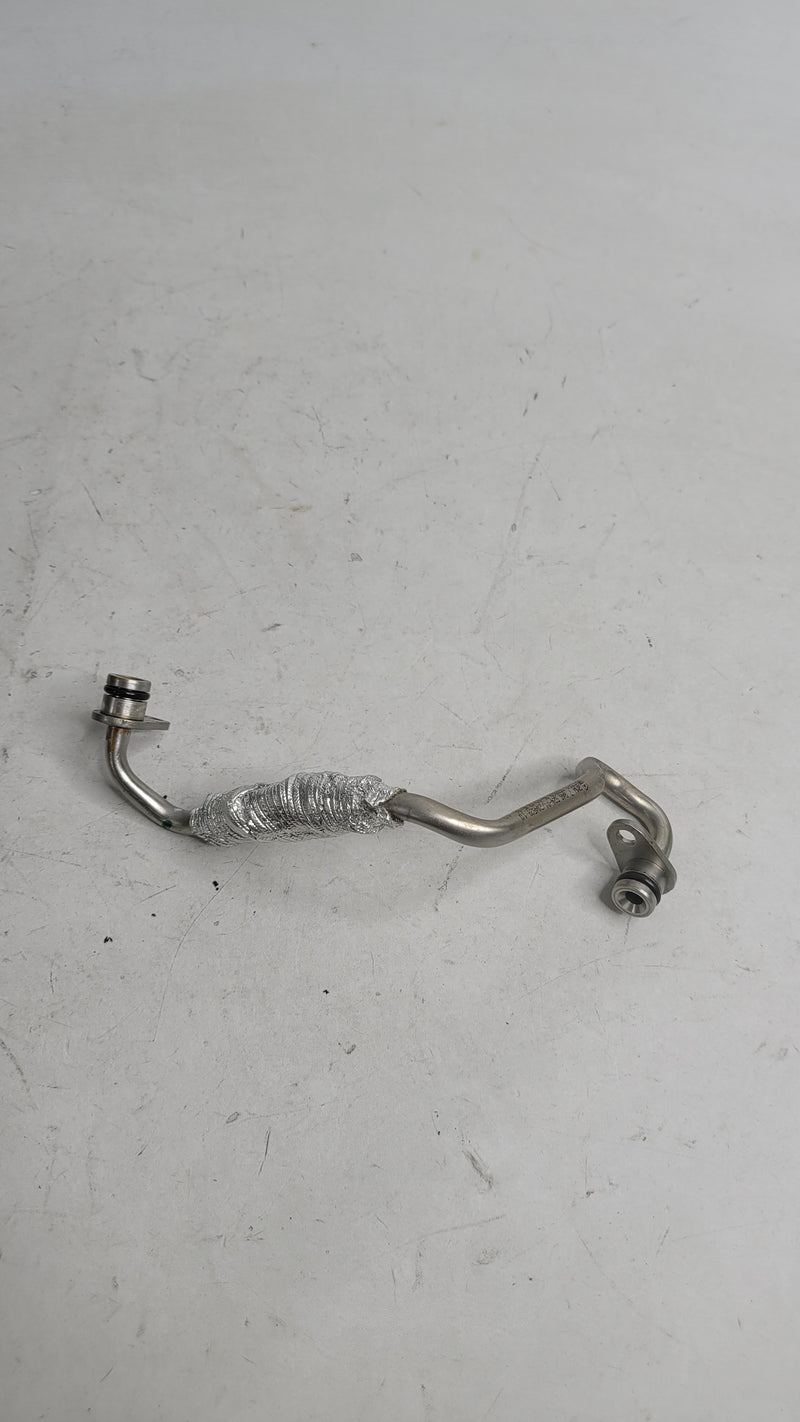 BMW M4 3.0L turbo inlet oil hose from MPerformance.parts, close-up view showing flexible rubber line with metal fittings