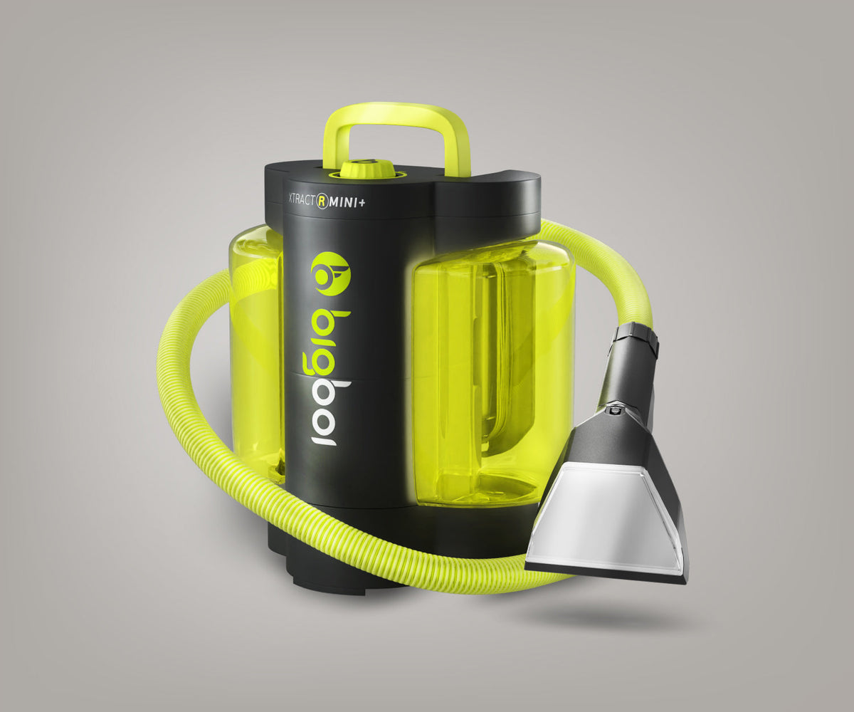 BigBoi XTRACTR MINI+ vehicle upholstery cleaner showing spray nozzle and clean fabric upholstery surface.