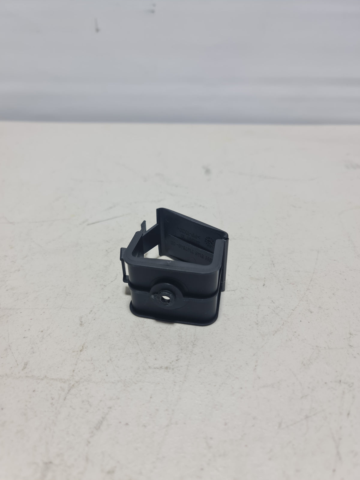BMW hazard warning triangle bracket for 2007-2020 models, black plastic mounting support with labeling and bolt holes.