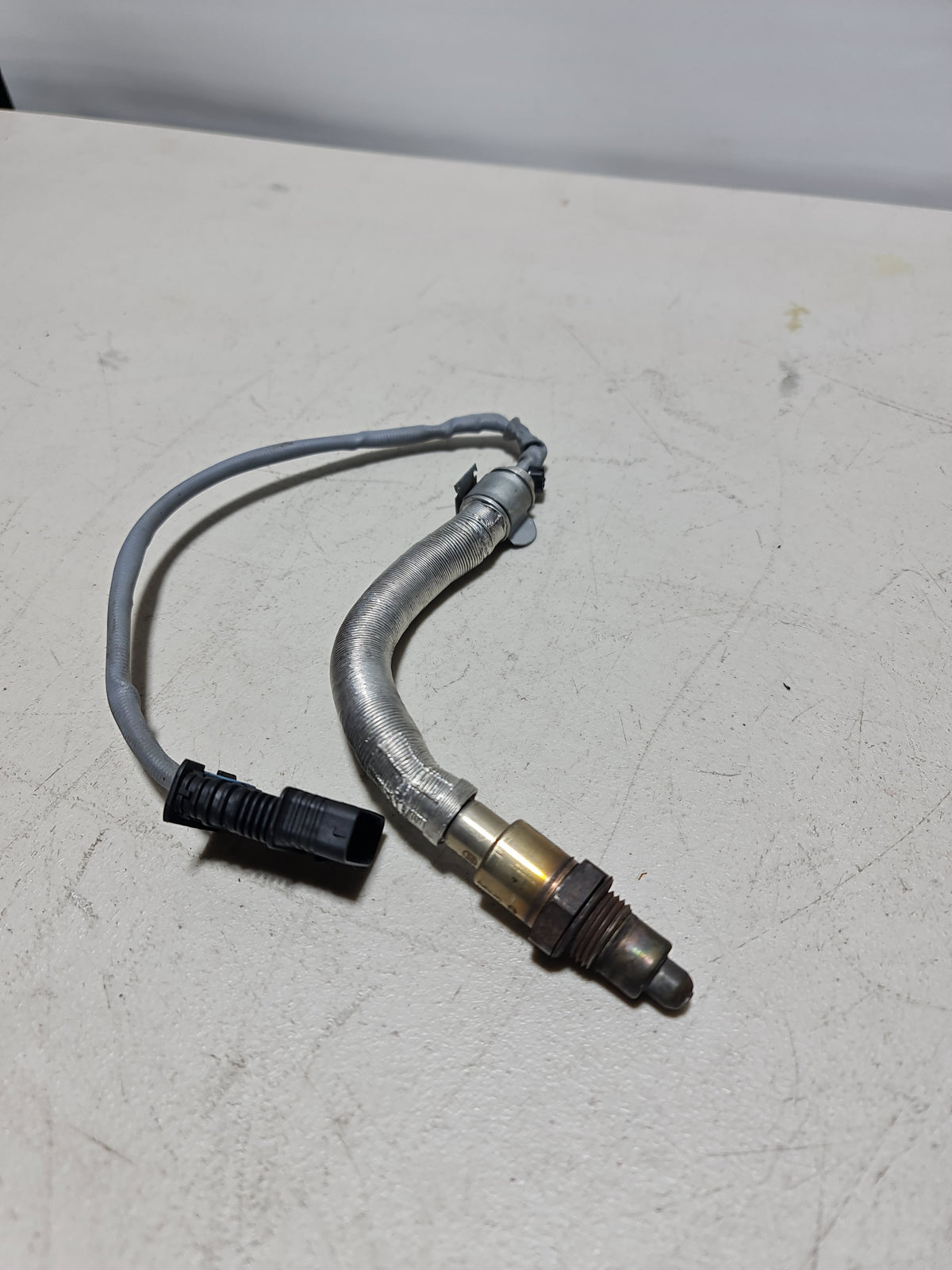 BMW brake hose 7348487-02 95325A, flexible automotive brake line, shown in close-up with detailed fittings and hose texture.