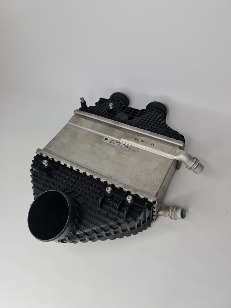 BMW charge-air cooler for 2015-2020 models, OEM part 17-51-7-846-235, with cooling fins and connector ports visible.