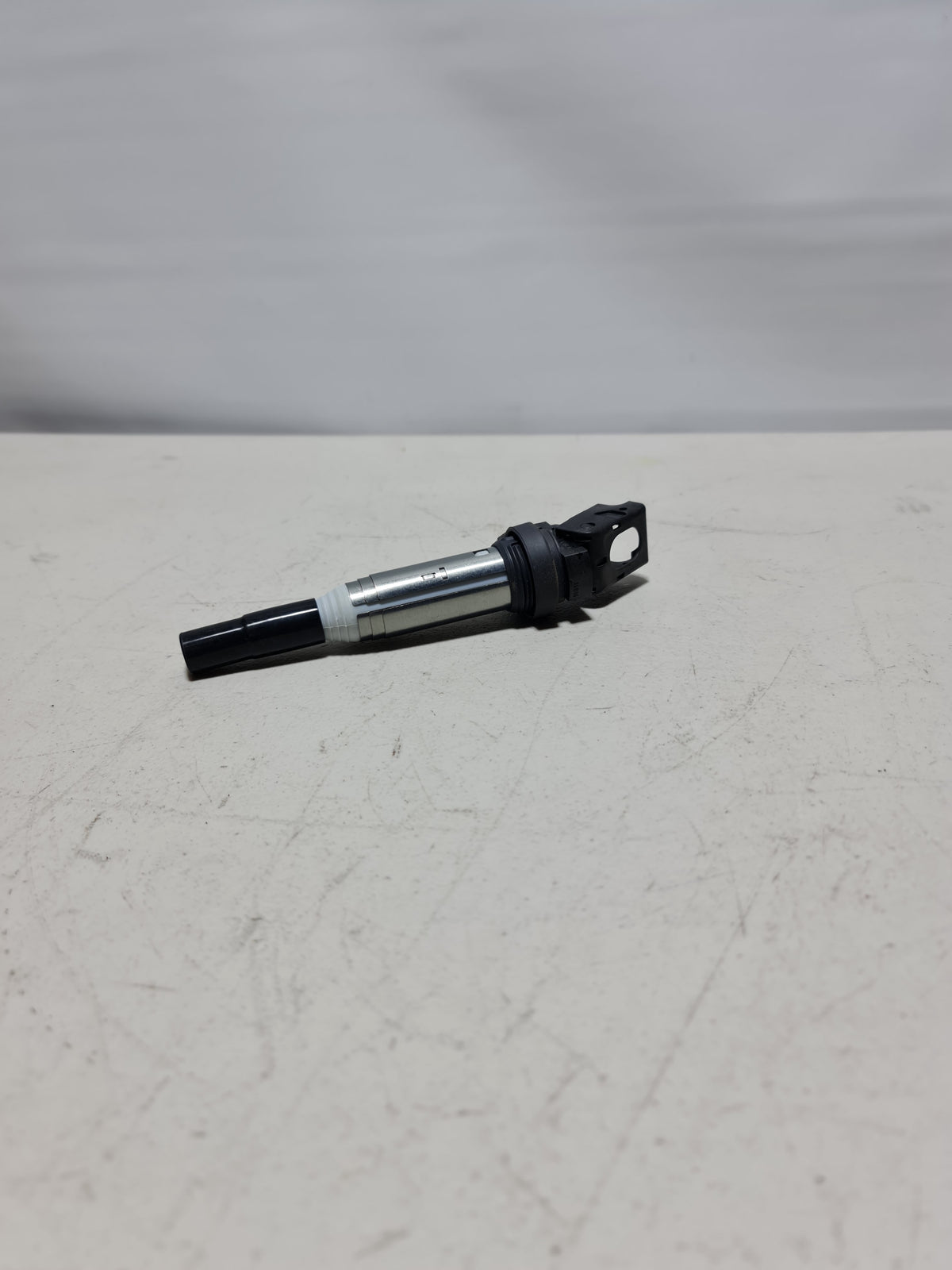 BMW ignition coil for models 2001-2020, automotive part with black cylindrical body and electrical connectors.