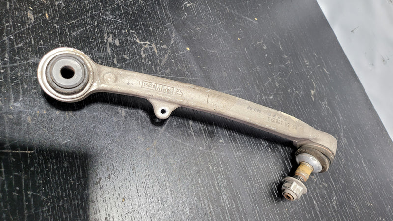 F80 left front control arm made of 6082T6 aluminum by MPerformance.parts, showing the sturdy metal component with mounting points.