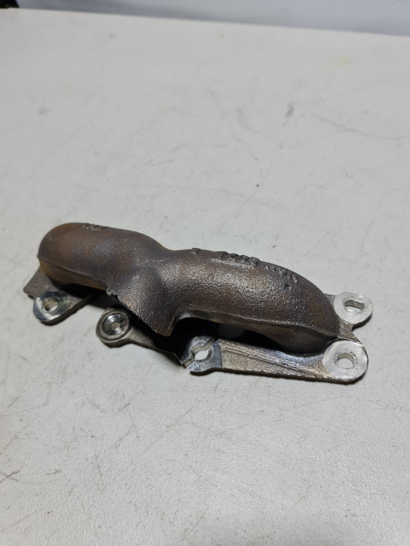 Damaged MPerformance.parts S55 F80 M3 turbo manifold with visible cracks and wear, showcasing the damaged metal structure.