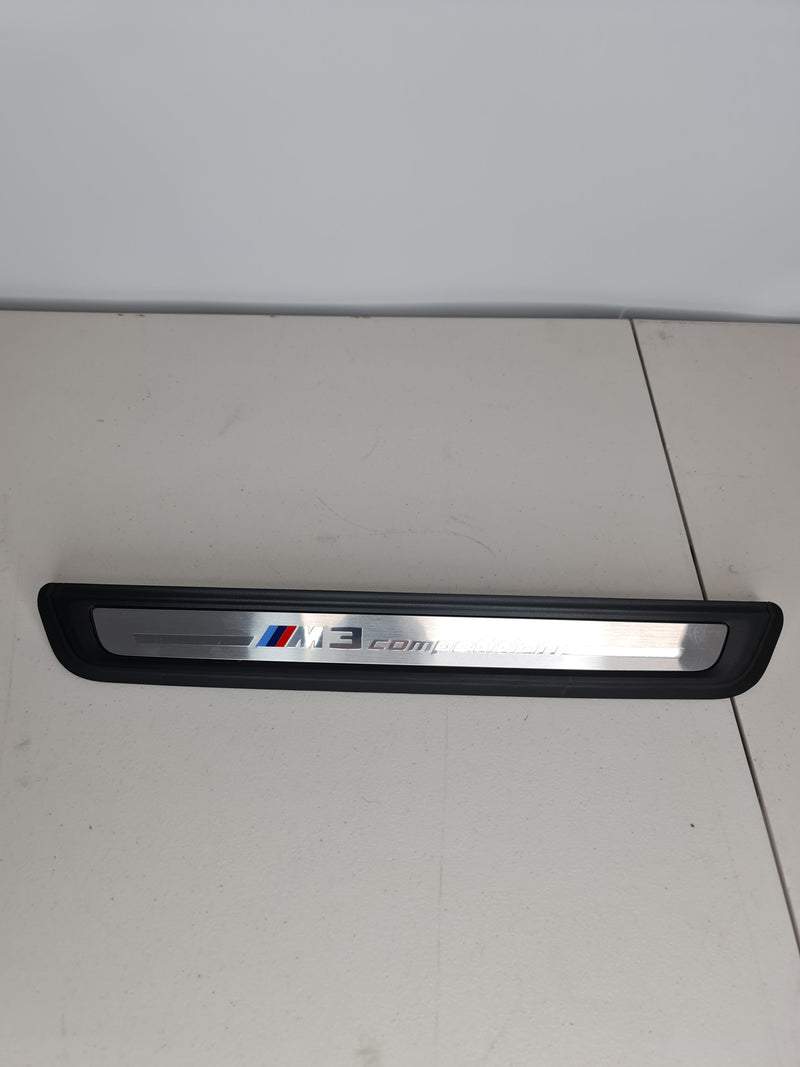 BMW G80 M3 Competition OEM front door sill kick plate by MPerformance.parts, showing sleek metal finish and mounting design.