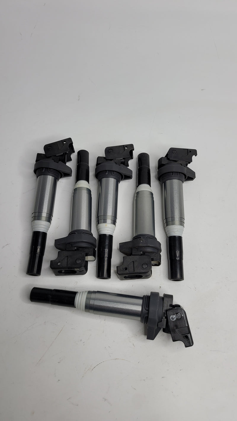 Set of 6 new BMW ignition coils from MPerformance.parts, shown with black plastic and metal connectors for BMW engine ignition system.
