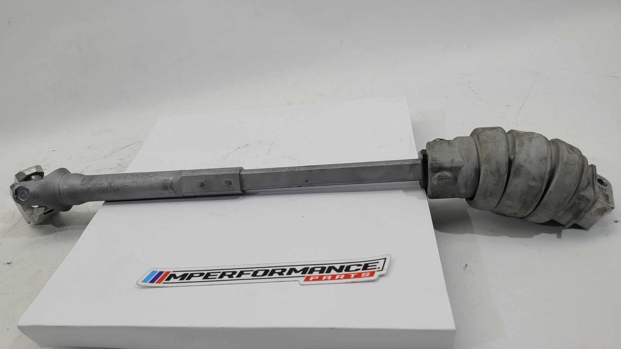 BMW M3 M4 G80 G82 G83 Competition XDrive steering column shaft joint spindle, black metal component with mounting points.