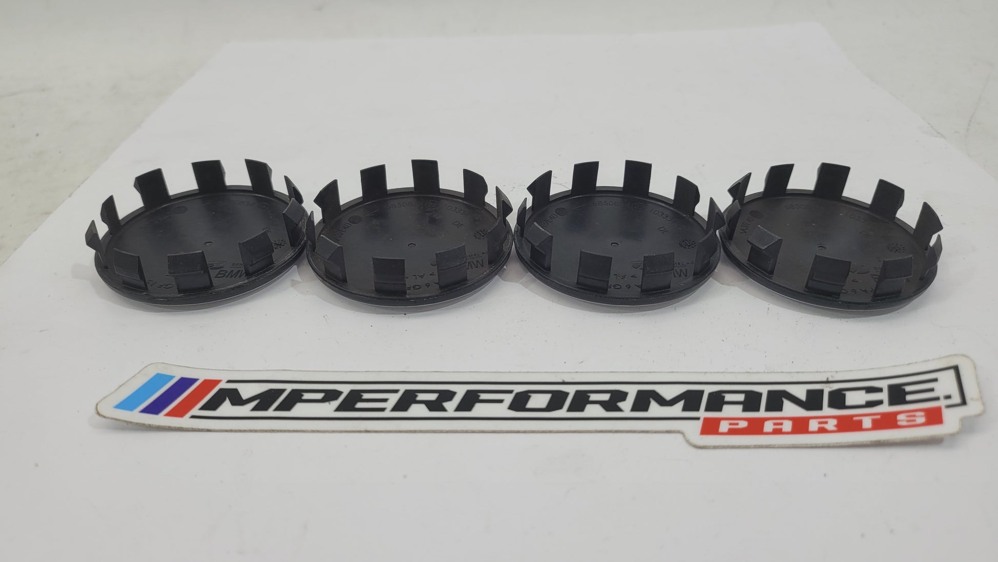 Set of four BMW 50th Anniversary G80 wheel caps featuring MPerformance.parts branding and detailed design for G80 series wheels.