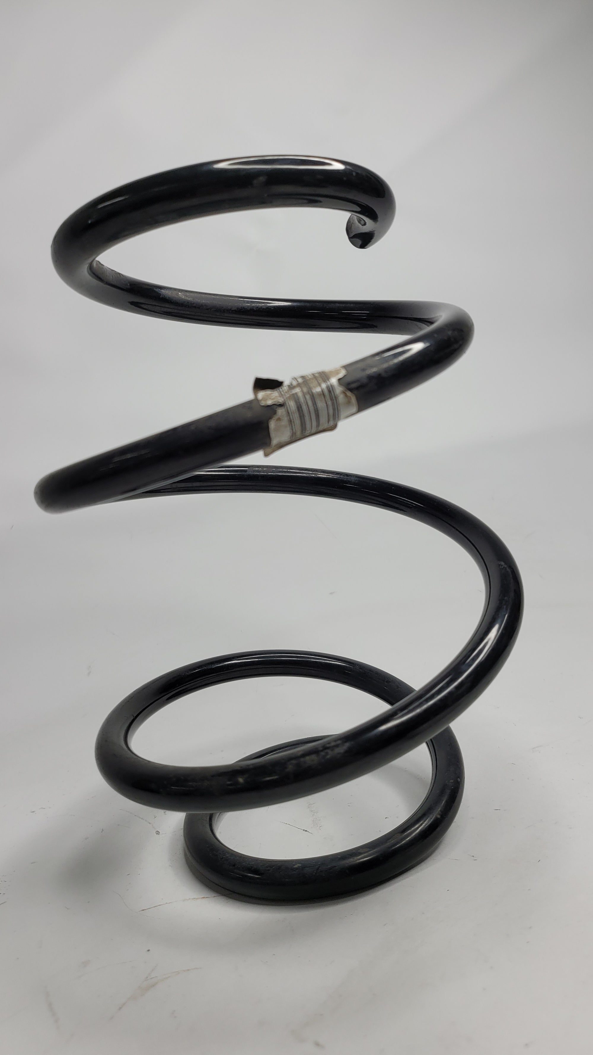 BMW F8X M2/3/4 front spring from MPerformance.parts showing the coil spring with mounting points and metallic finish.