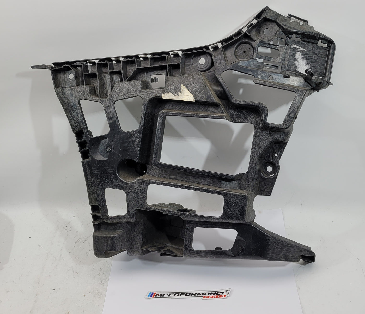 BMW M3 M4 G80 G82 rear left bumper corner bracket by MPerformance.parts, showing the black metal car part with mounting points.