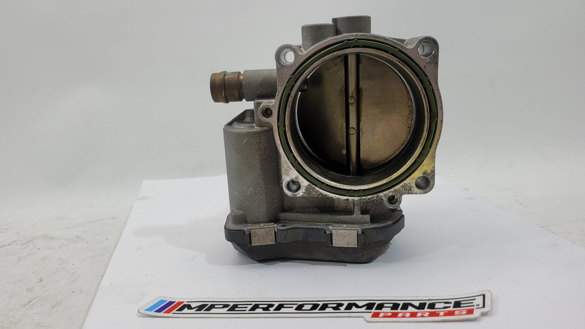 BMW M3 M4 F80 F82 F83 S55 engine throttle body by MPerformance.parts, showing the metallic component with mounting points and connectors.