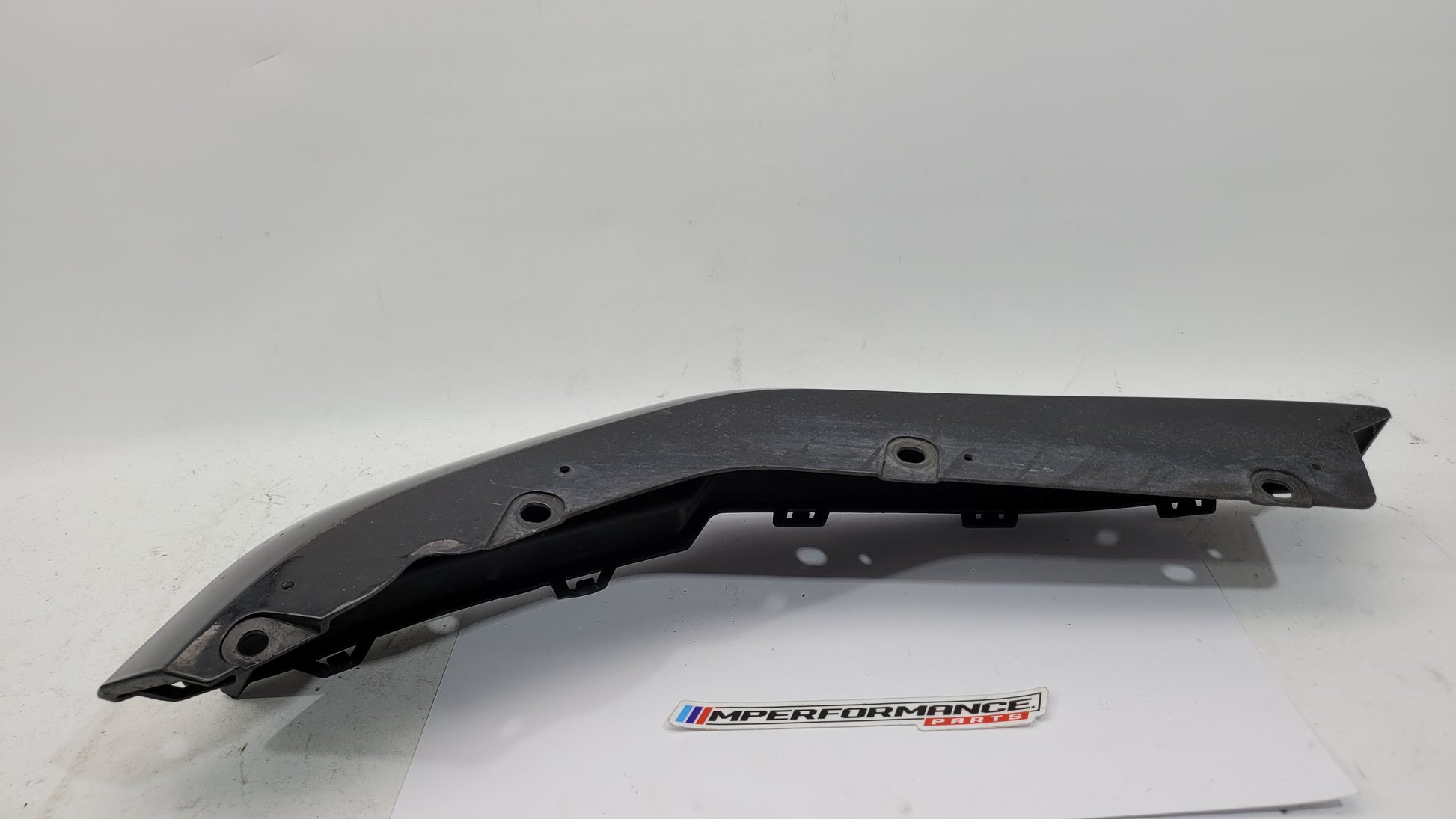 BMW G80 M3 rear right bumper corner spat splitter by MPerformance.parts, showing the aerodynamic side piece on the vehicle.