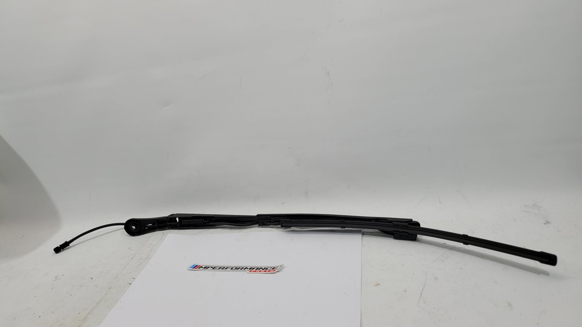 BMW M3 G8x passenger side front wiper arm by MPerformance.parts, showing the metal wiper arm with mounting attachment.
