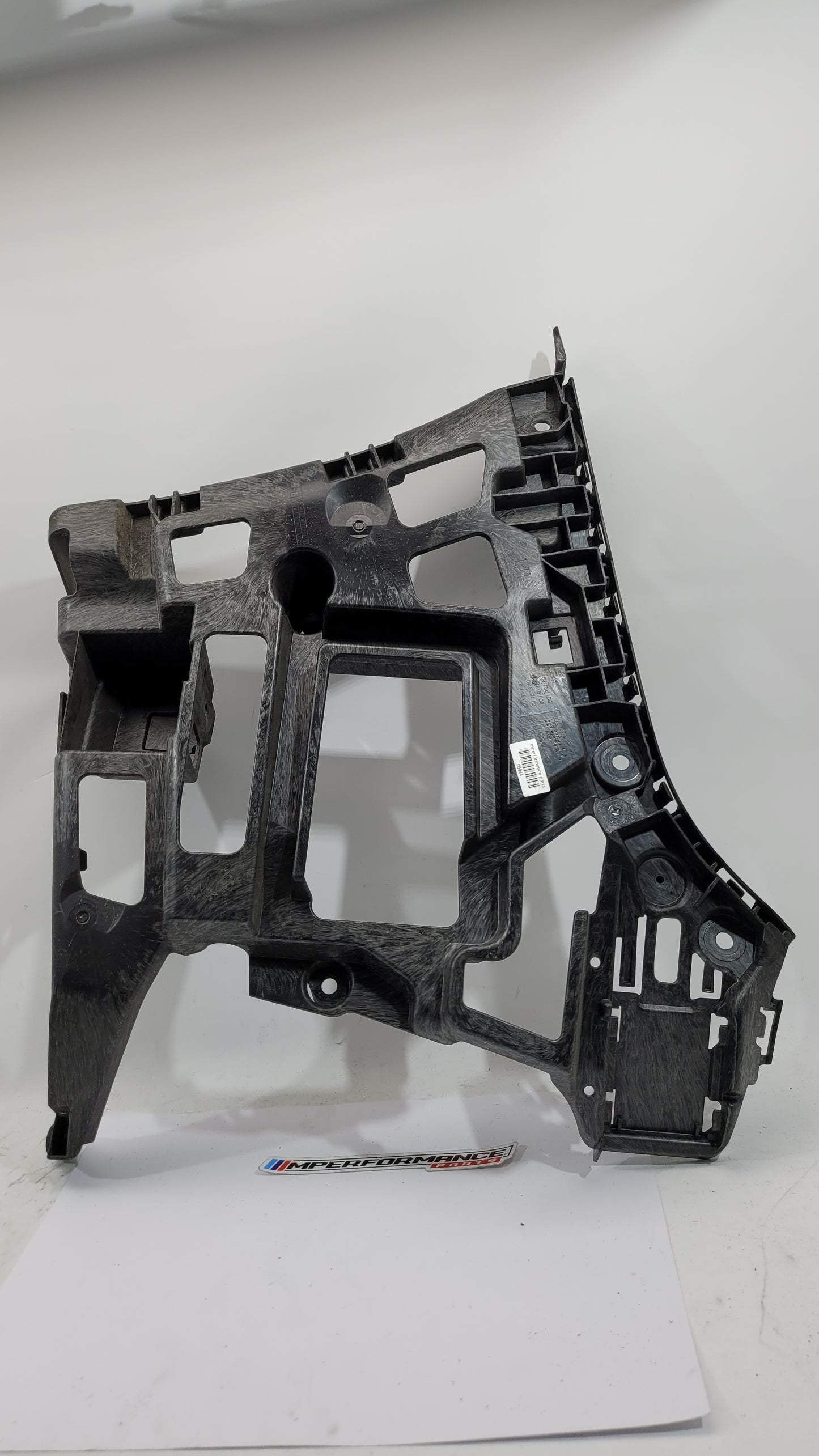 BMW G80 M3 rear left bumper holder bracket, part 8069445, in black with mounting points and structural design.