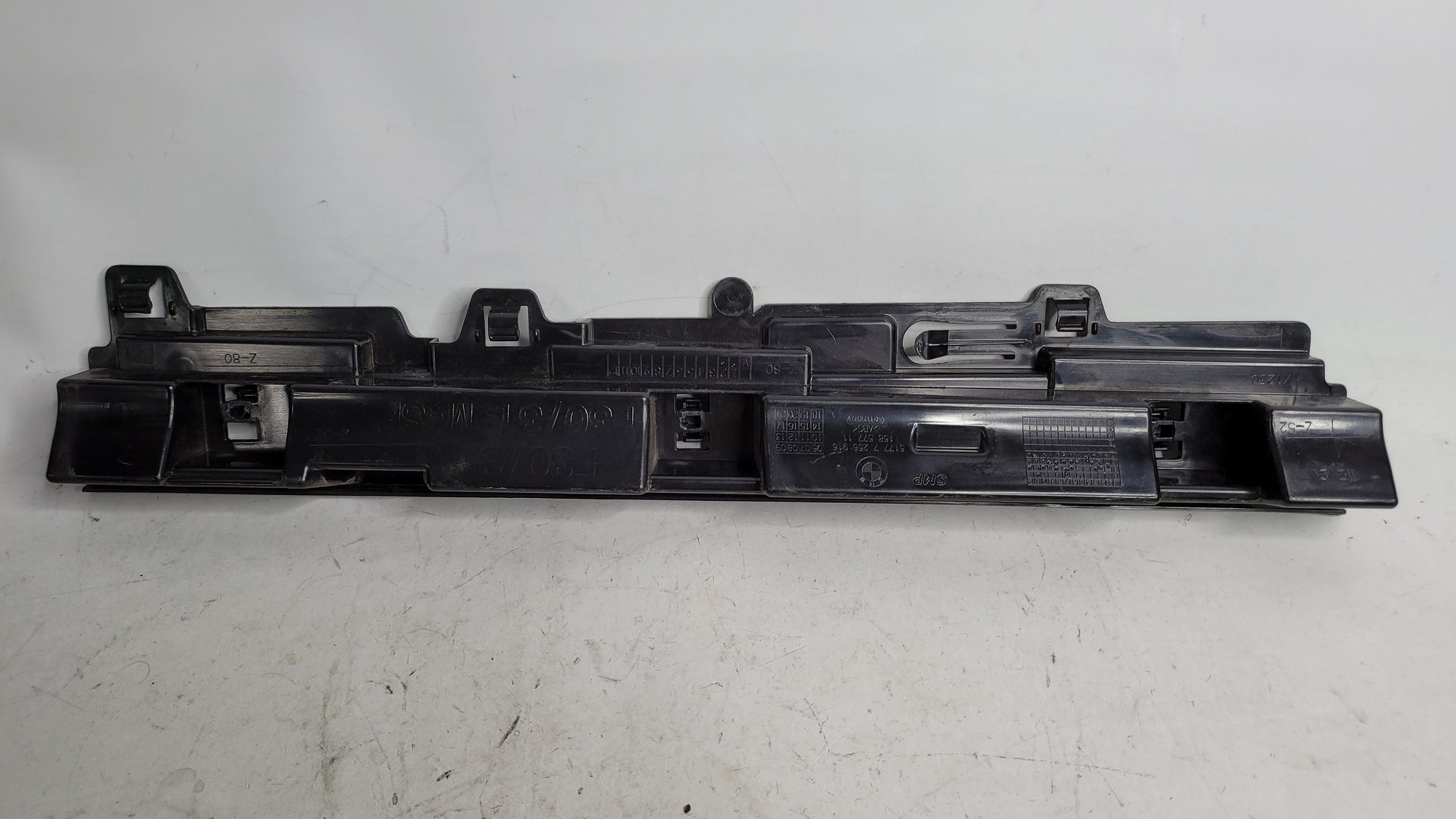 BMW 320i right skirt rocker panel support bracket by MPerformance.parts, showing the metal bracket with mounting points.