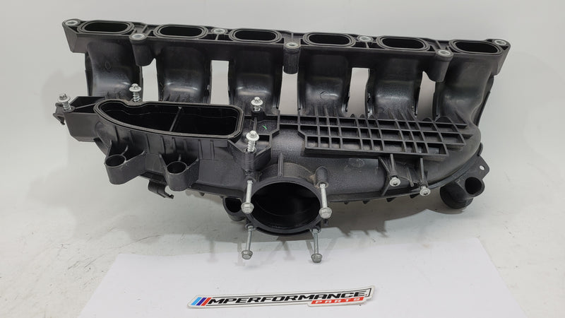 BMW N55 S55 3.0L engine intake manifold from MPerformance.parts, showing a close-up of the black plastic intake manifold with mounting points.