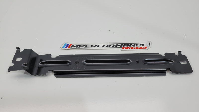 BMW M3 G80 battery hold down clamp by MPerformance.parts, showing the metal clamp securing the vehicle's battery in the engine bay.