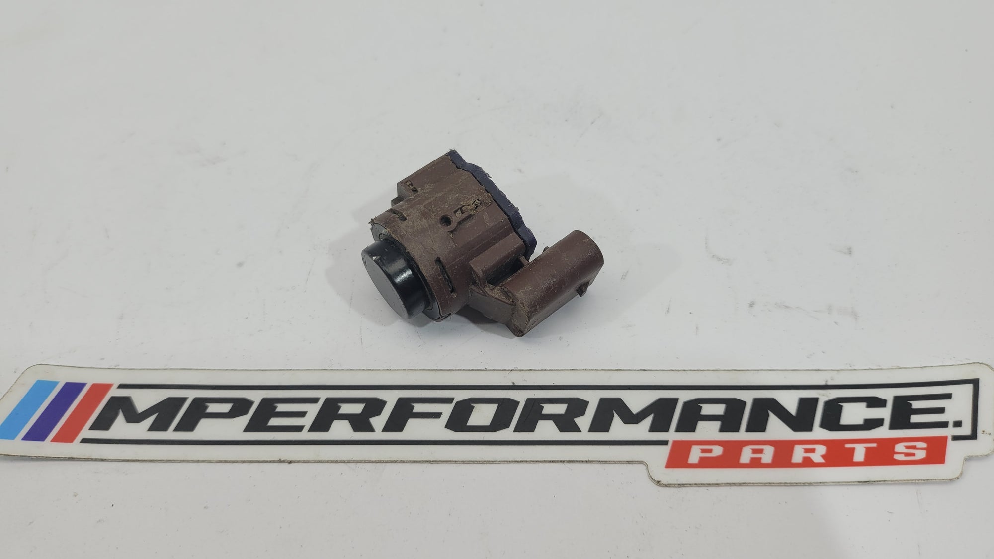 BMW M2 G87 bumper PDC parking distance sensor from MPerformance.parts, showing a close-up of the sensor integrated into the bumper.