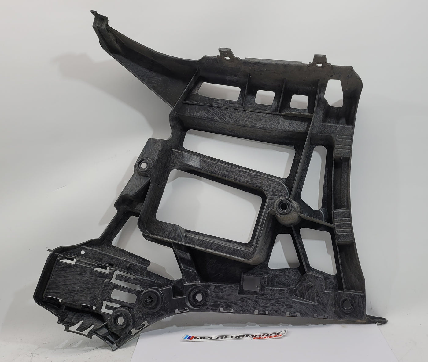 BMW M3 CS G80 rear bumper support bracket on driver side, black metal component with mounting points and structural design