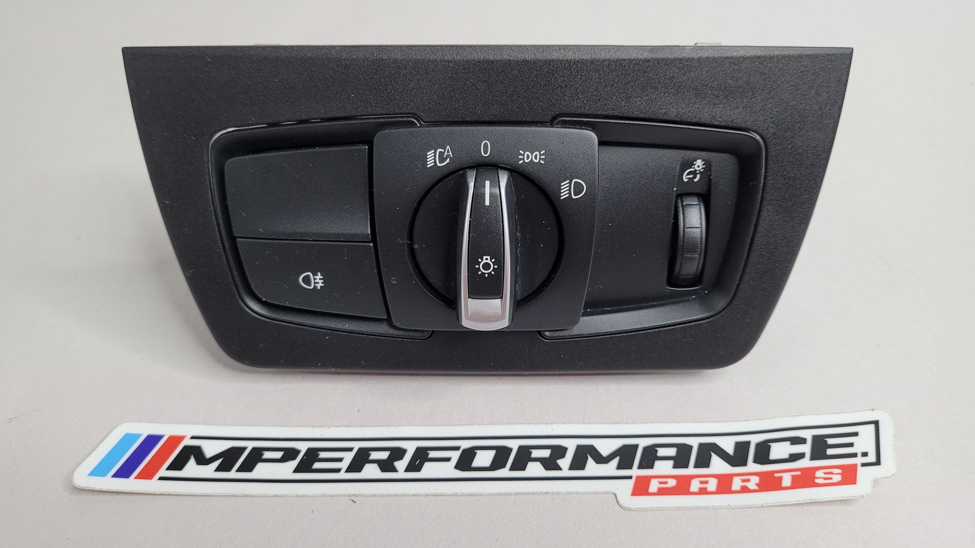 BMW 3 Series F30 headlight control switch by MPerformance.parts, showing the switch with labeled buttons and connectors.