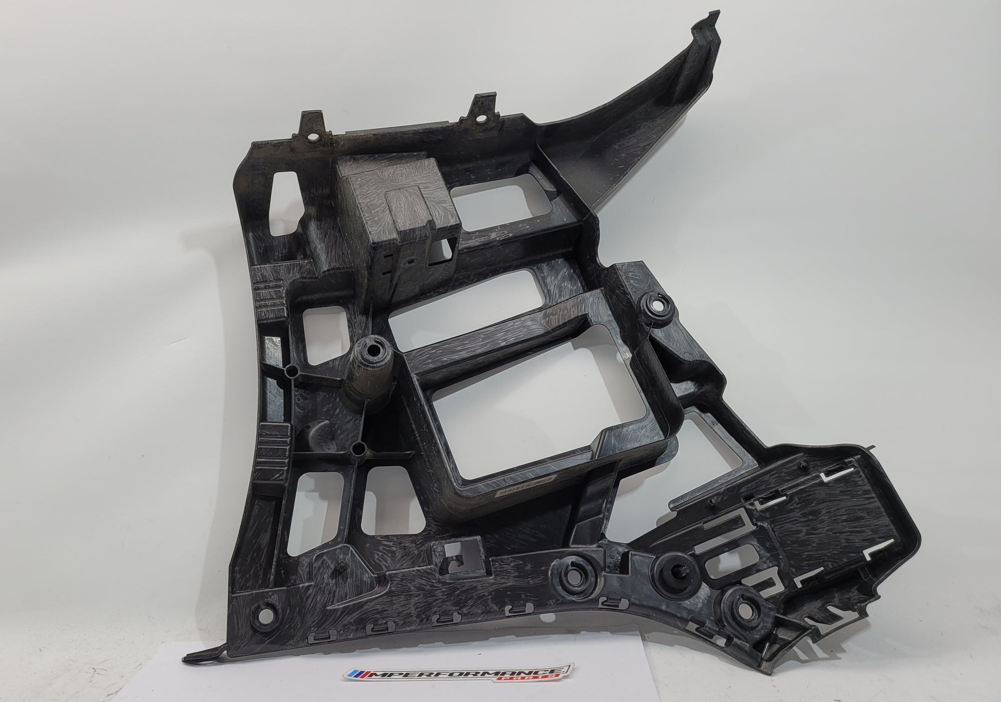 BMW M3 M4 G80 G82 rear left bumper corner bracket by MPerformance.parts, showing the black metal mounting component.