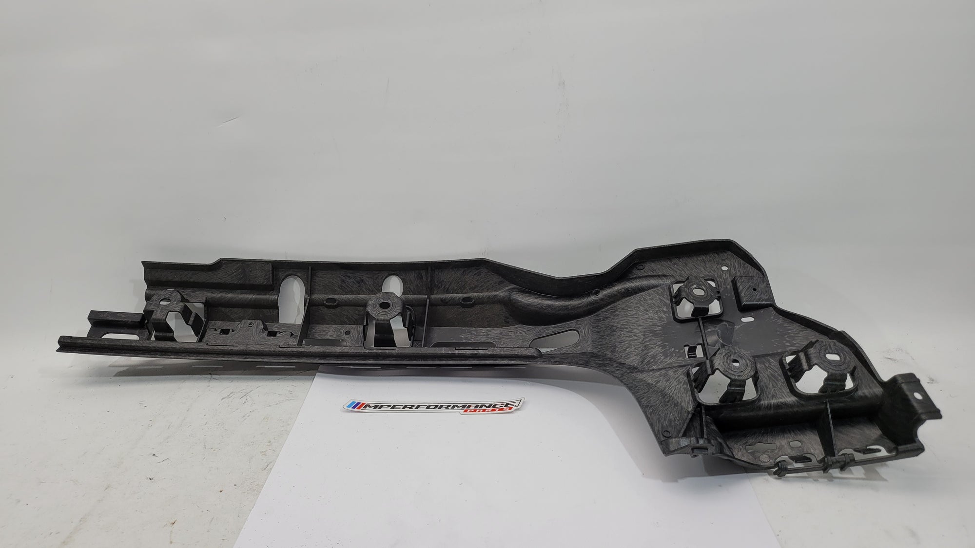 BMW M3 G80 rear bumper right bracket, part number 8074698, in black with mounting points visible for vehicle repair or replacement.