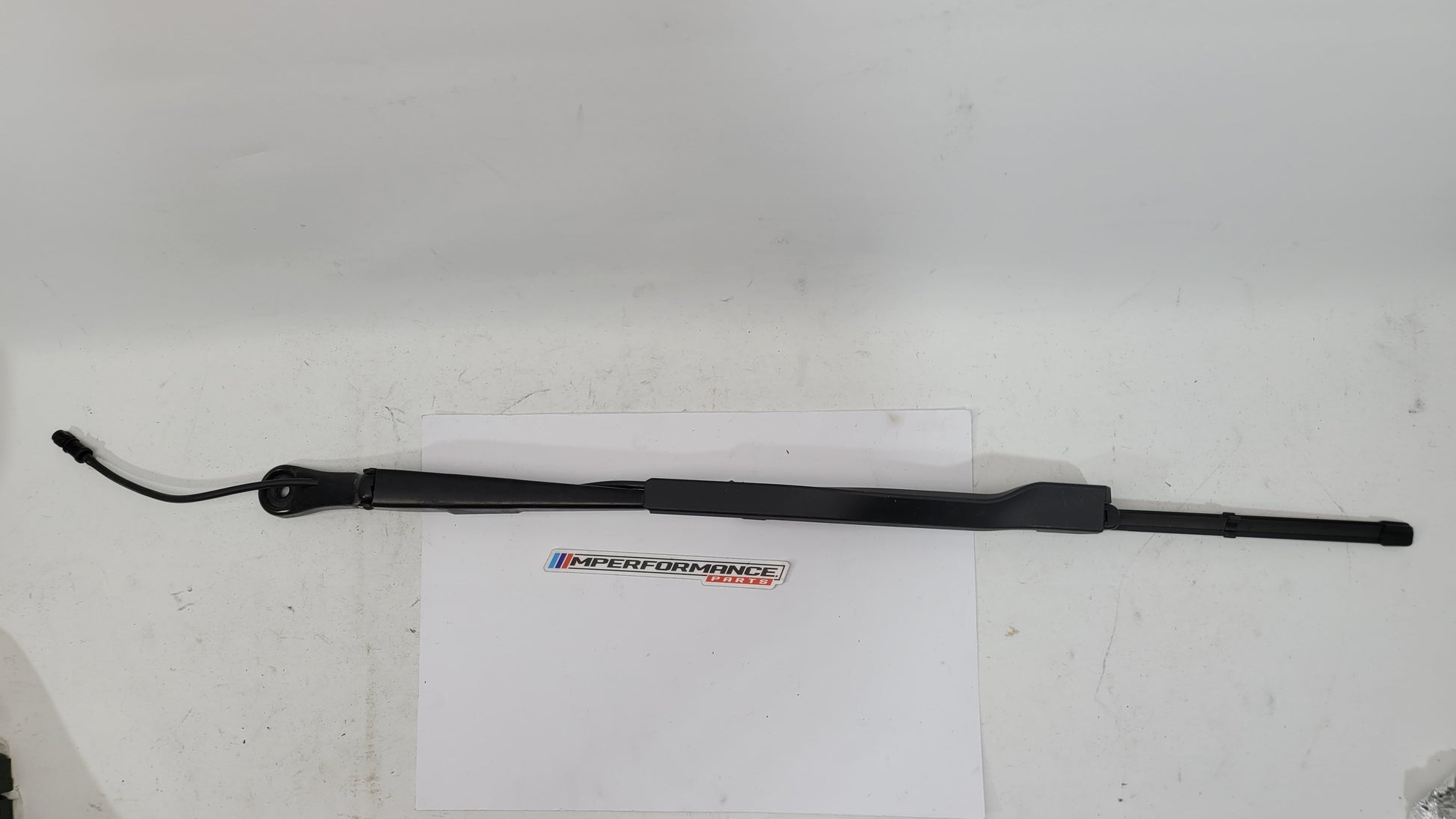 BMW M3 G8x passenger side front wiper arm by MPerformance.parts, showing the metal wiper arm with mounting details.