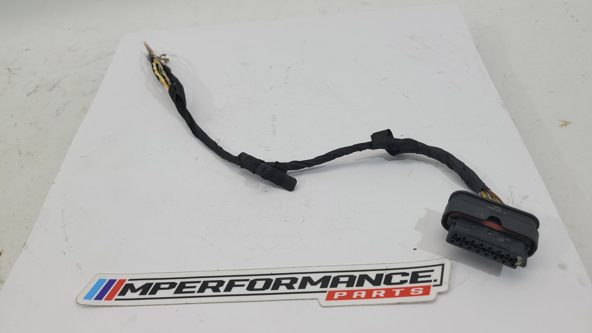 BMW parking sensor socket housing by MPerformance.parts, showing close-up of the connector and mounting details.