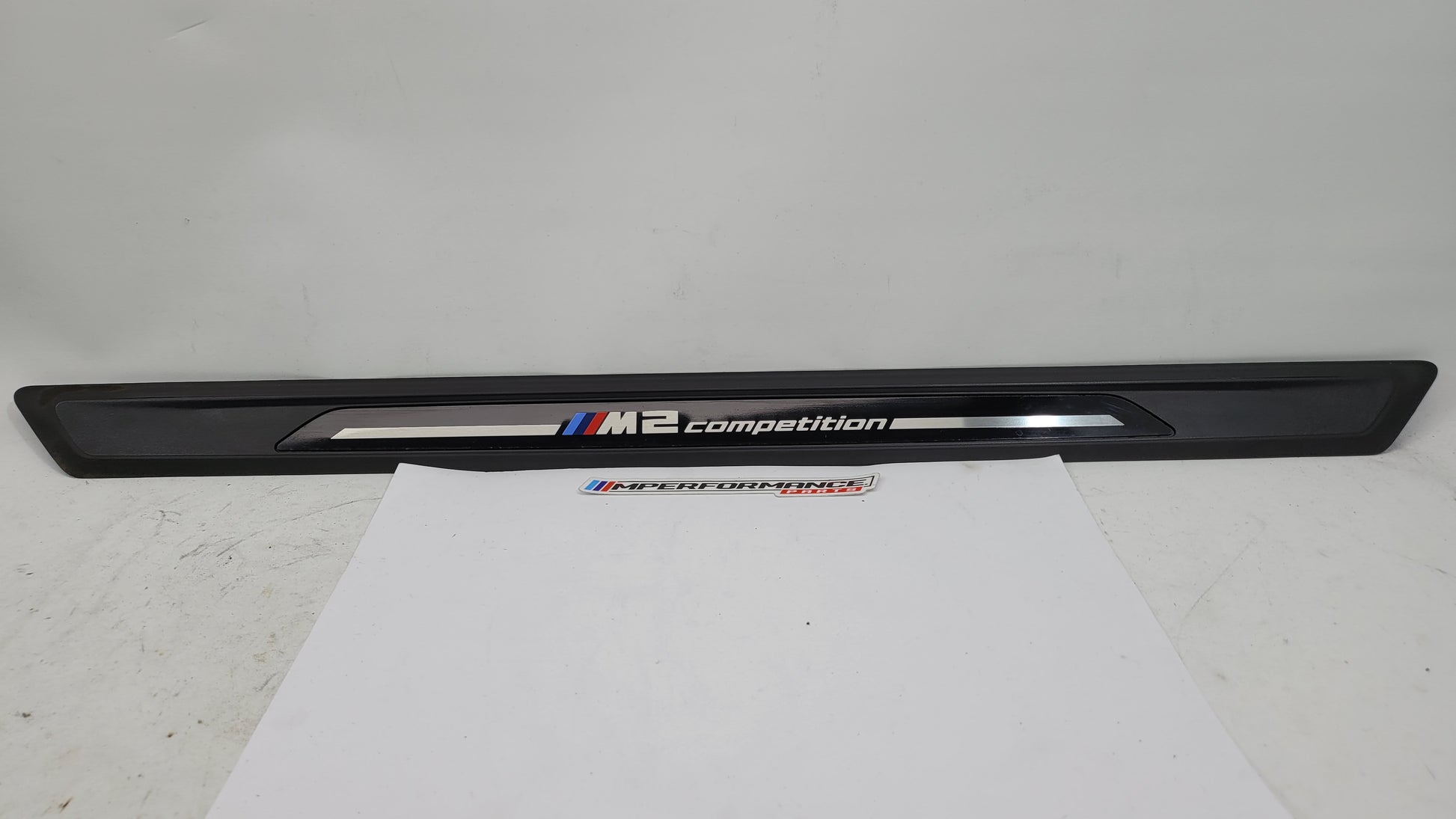 BMW M2 Competition F87 door sill scuff plate, left or right, with MPerformance.parts branding, shown in close-up view.