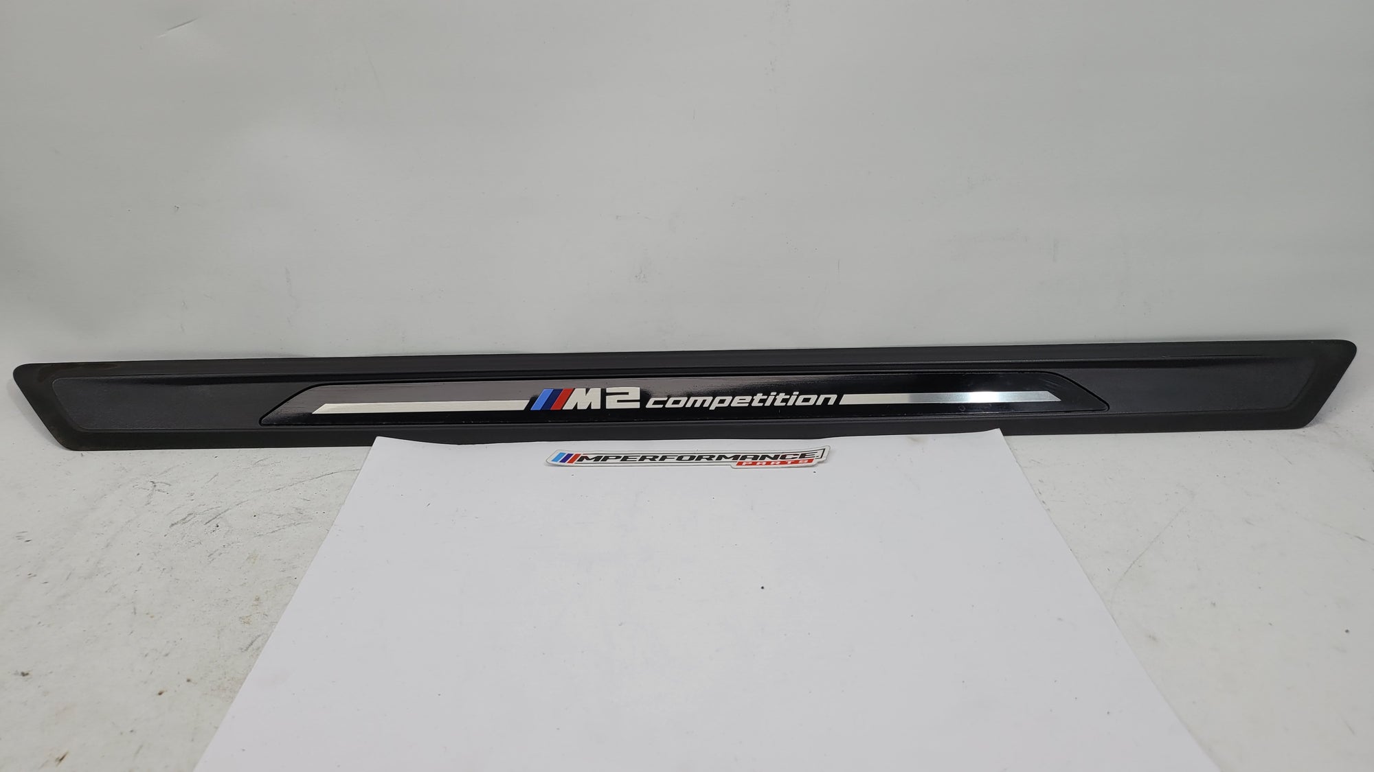 BMW M2 Competition F87 door sill scuff plate, left or right, with MPerformance.parts branding, shown in close-up view.