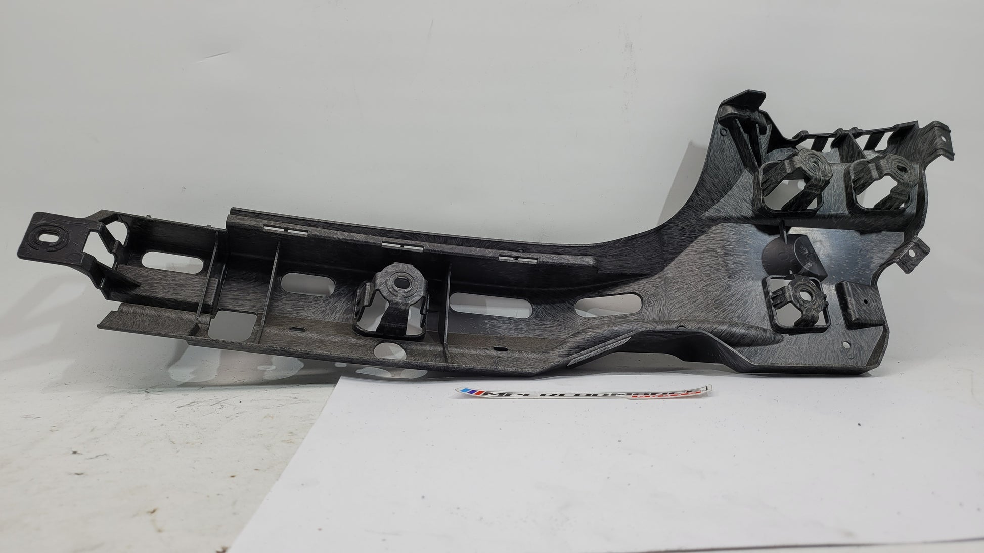 BMW M3 G80 rear left passenger side bumper bracket mount, part 8074697, showing the mounting bracket for the bumper assembly.