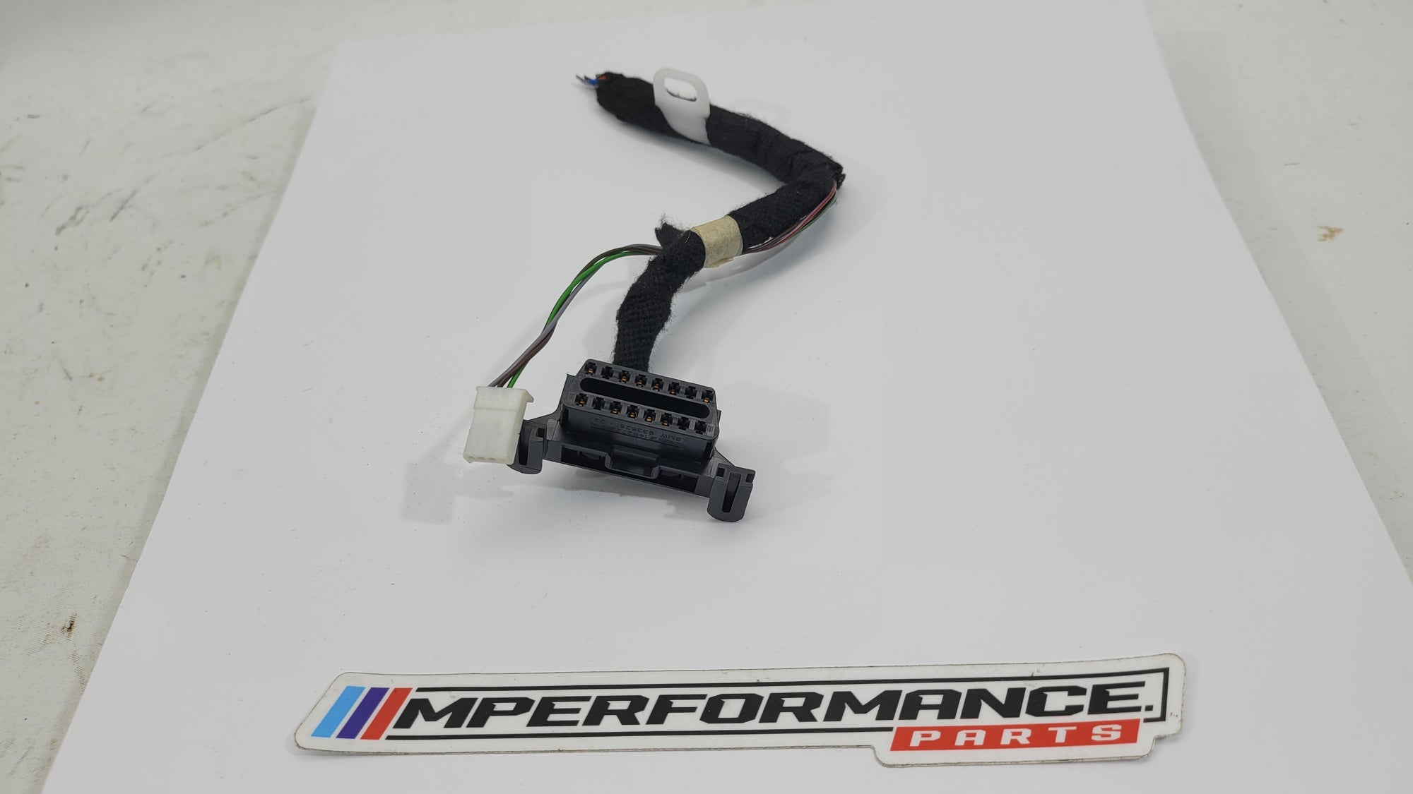 BMW OBD2 port 9335261 from MPerformance.parts, close-up of the black connector with wiring, designed for automotive diagnostics.