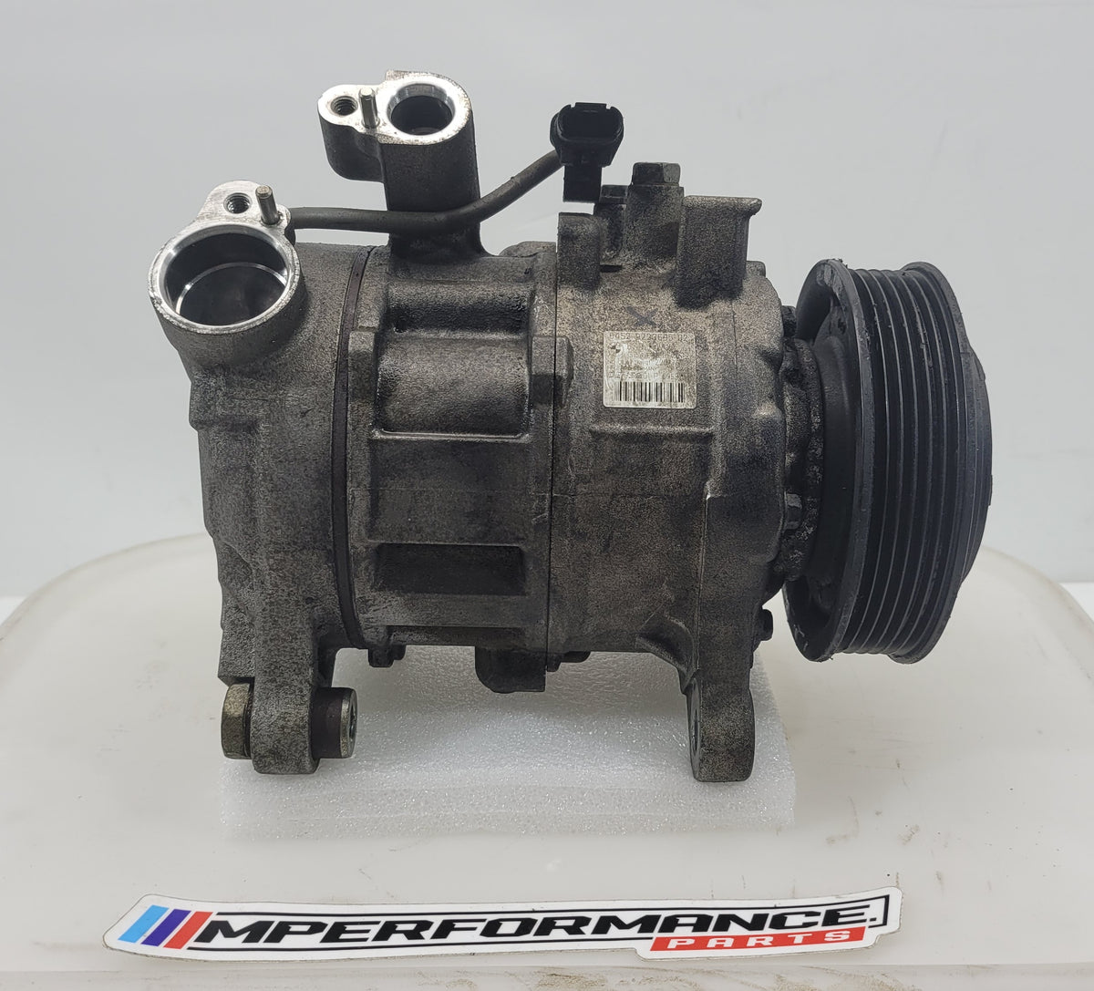Close-up of MPerformance.parts 6seu14a engine component with detailed metal surface and part numbers visible.
