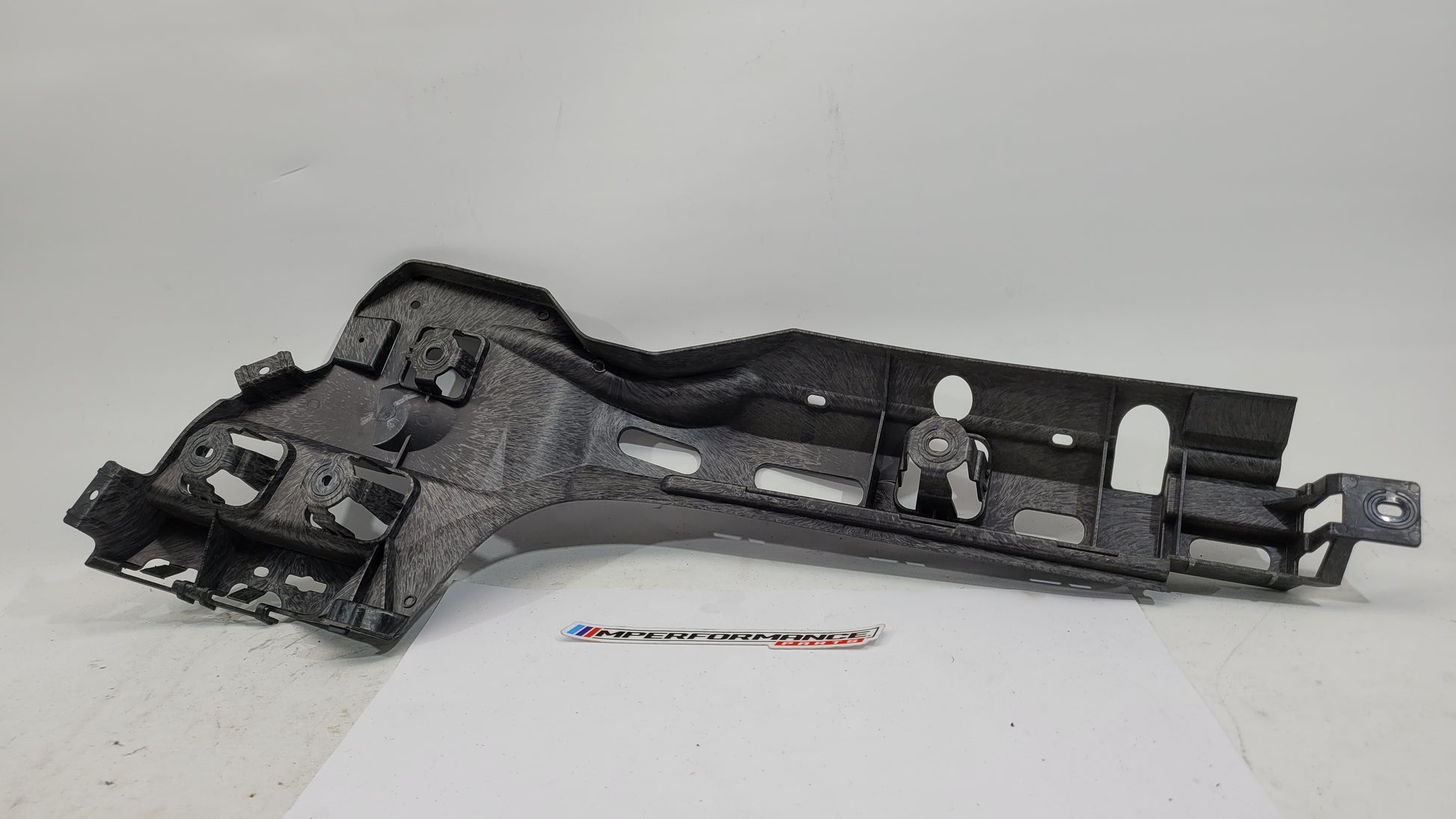 BMW M3 G80 rear left passenger side bumper bracket mount, automotive part from MPerformance.parts, showing mounting details and structure.