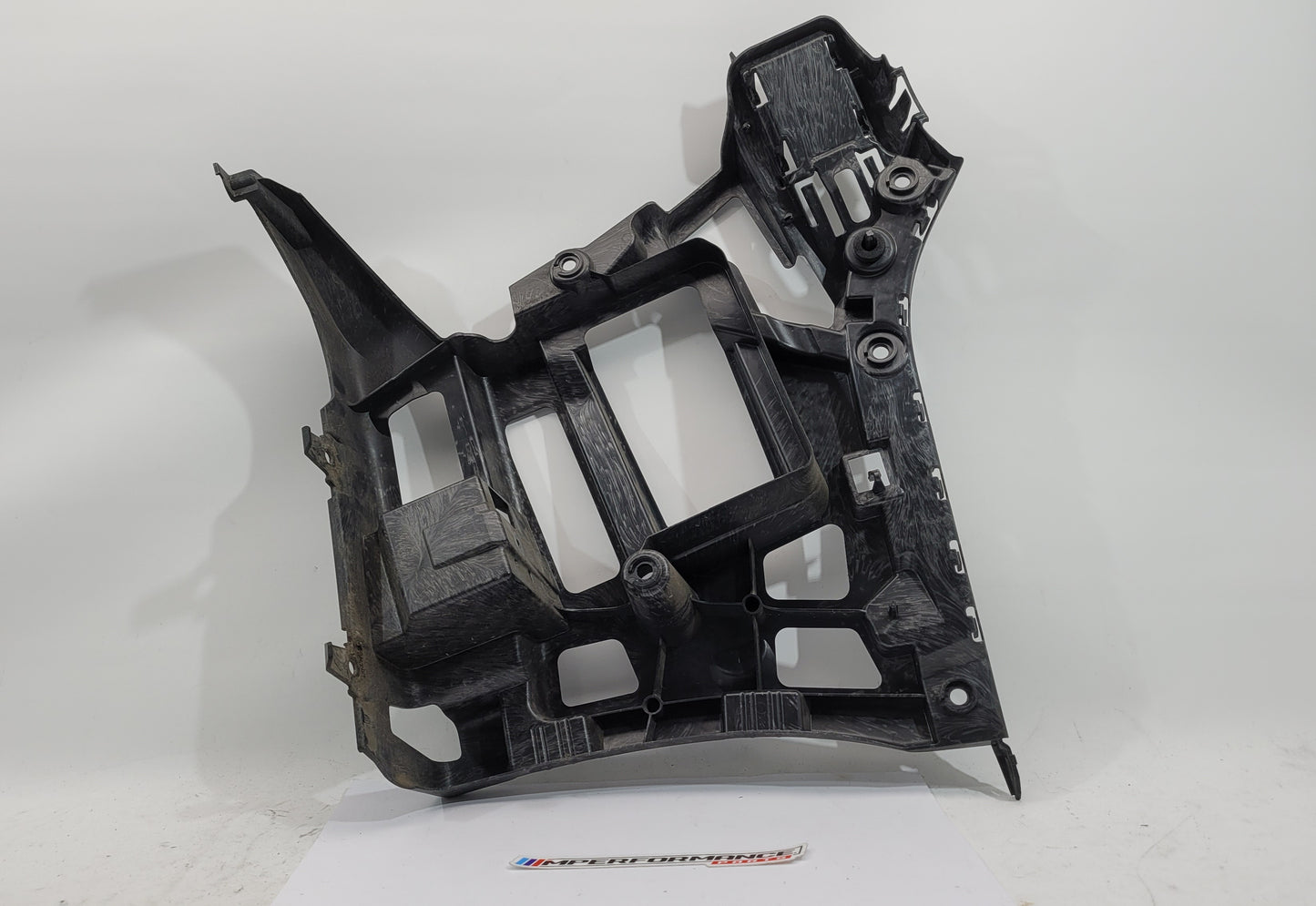 BMW M3 M4 G80 G82 rear left bumper corner bracket by MPerformance.parts, showing the metal mounting part in close-up.
