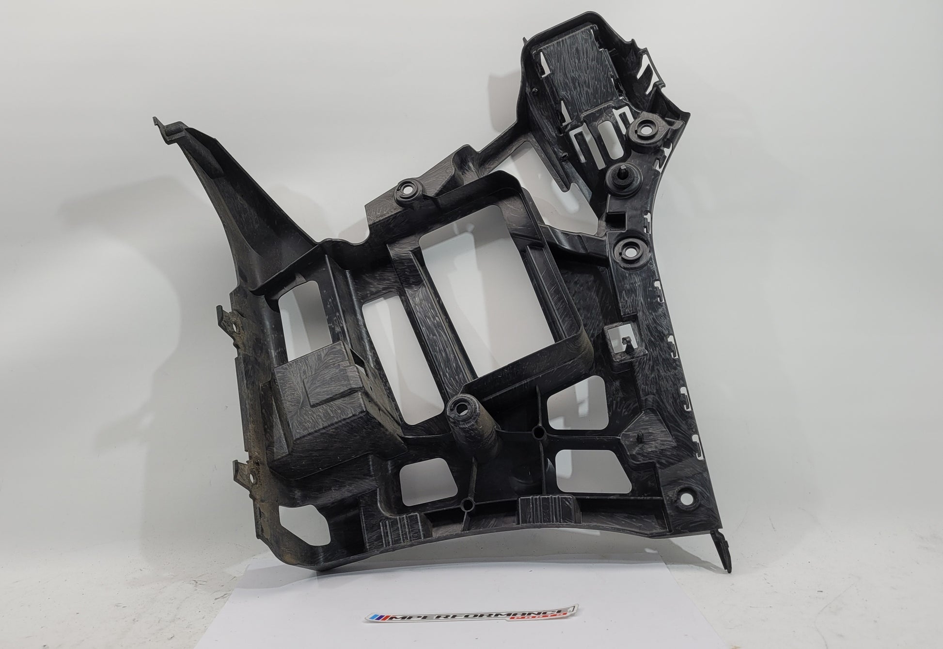 BMW M3 M4 G80 G82 rear left bumper corner bracket by MPerformance.parts, showing the metal mounting part in close-up.