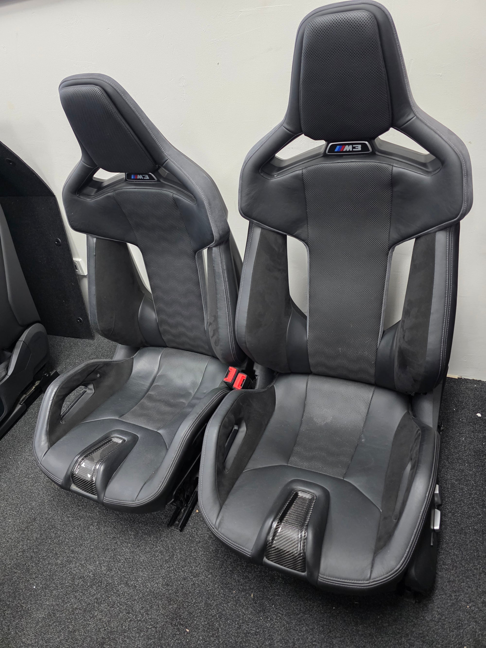 BMW G80 M3 front bucket seat with black leather and carbon fiber accents, featuring Merino leather upholstery and sporty design.