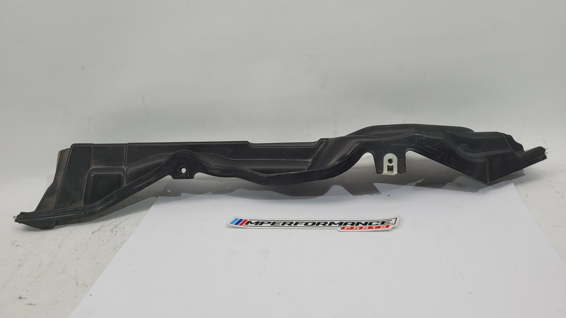 BMW M3 G8x engine compartment panel from MPerformance.parts, showing the black panel with mounting points and engine bay details.