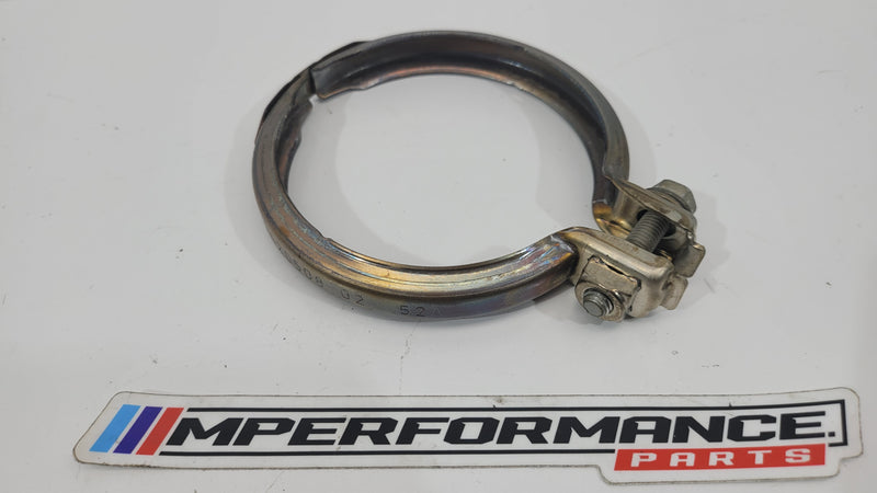 BMW M4 F82 exhaust pipe clamp by MPerformance.parts, showing a close-up of the black metal clamp securing exhaust components.