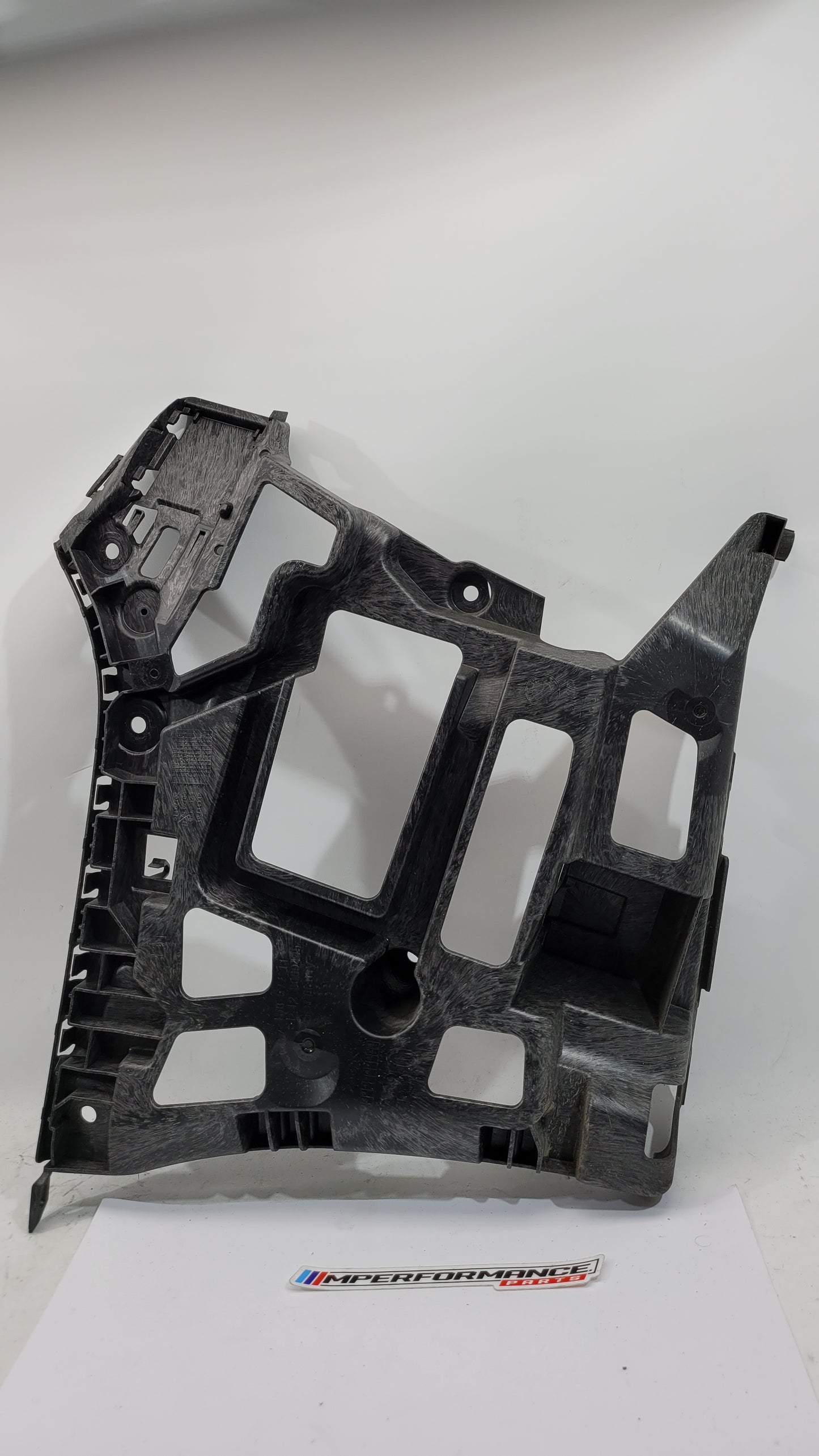 BMW G80 M3 rear left bumper holder bracket, part number 8069445, showing the metal bracket with mounting points and finish.