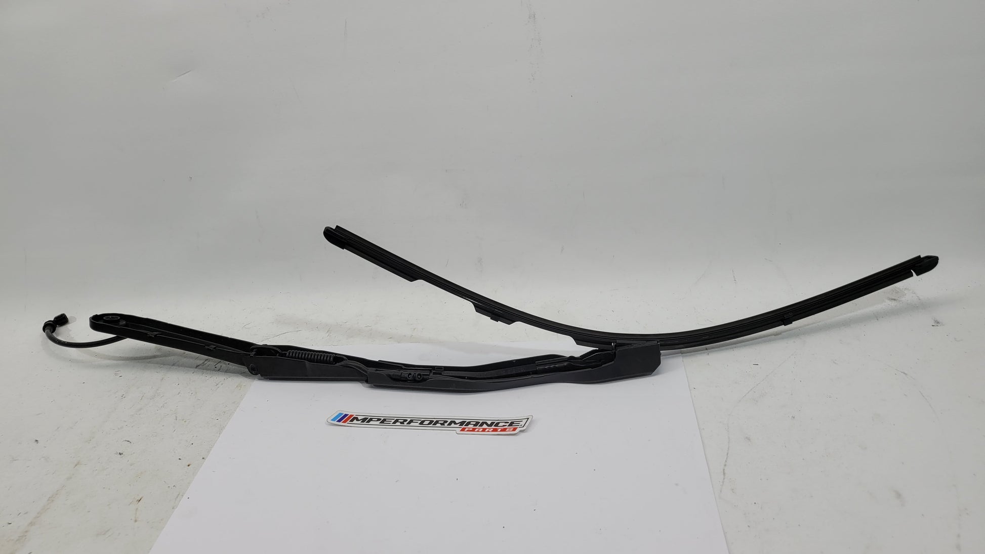 BMW M3 G8x driver side front wiper arm by MPerformance.parts, close-up of the black metal wiper arm attachment and mounting.