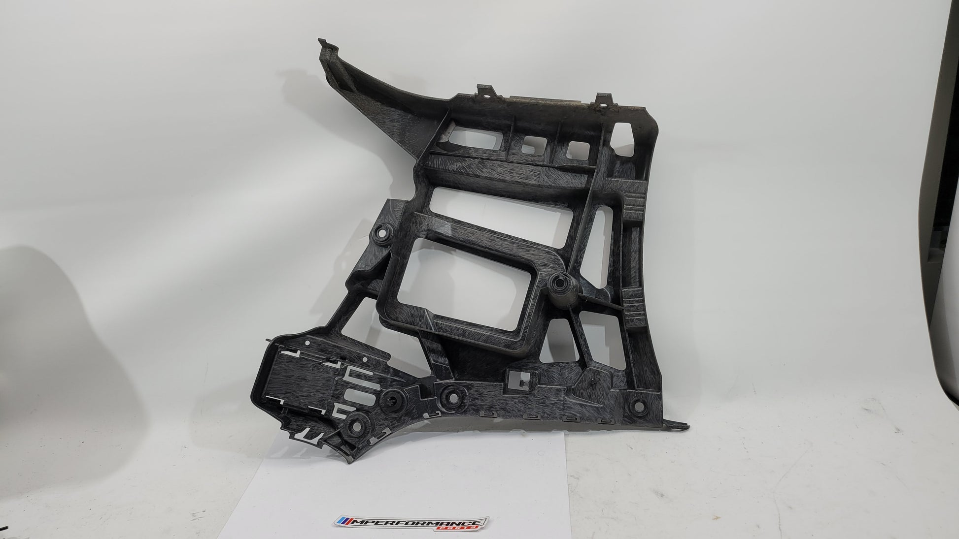 BMW M3 xDrive G80 rear bumper support bracket showing metal mounting points and structural design for vehicle stability.