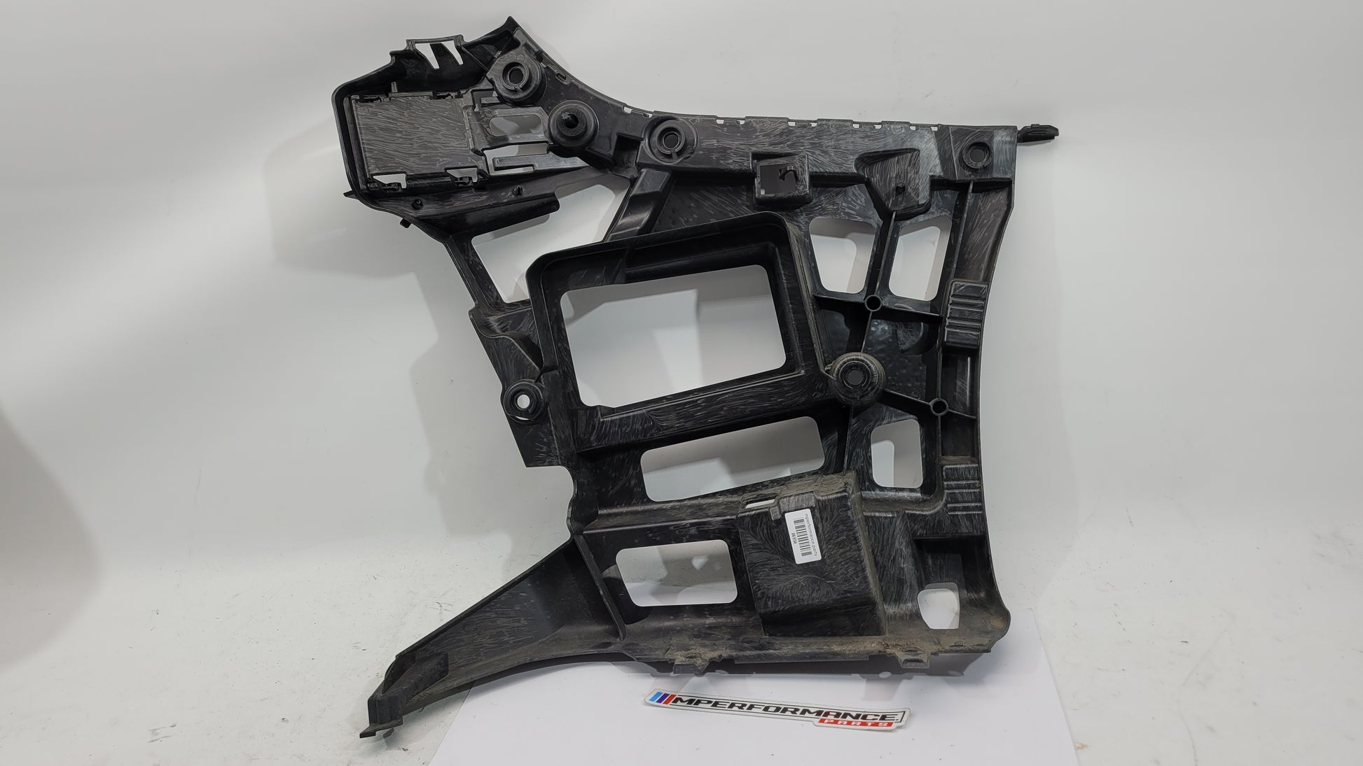 BMW M3 M4 G80 G82 rear left bumper corner bracket by MPerformance.parts, showing the metal mounting component with bolt holes.