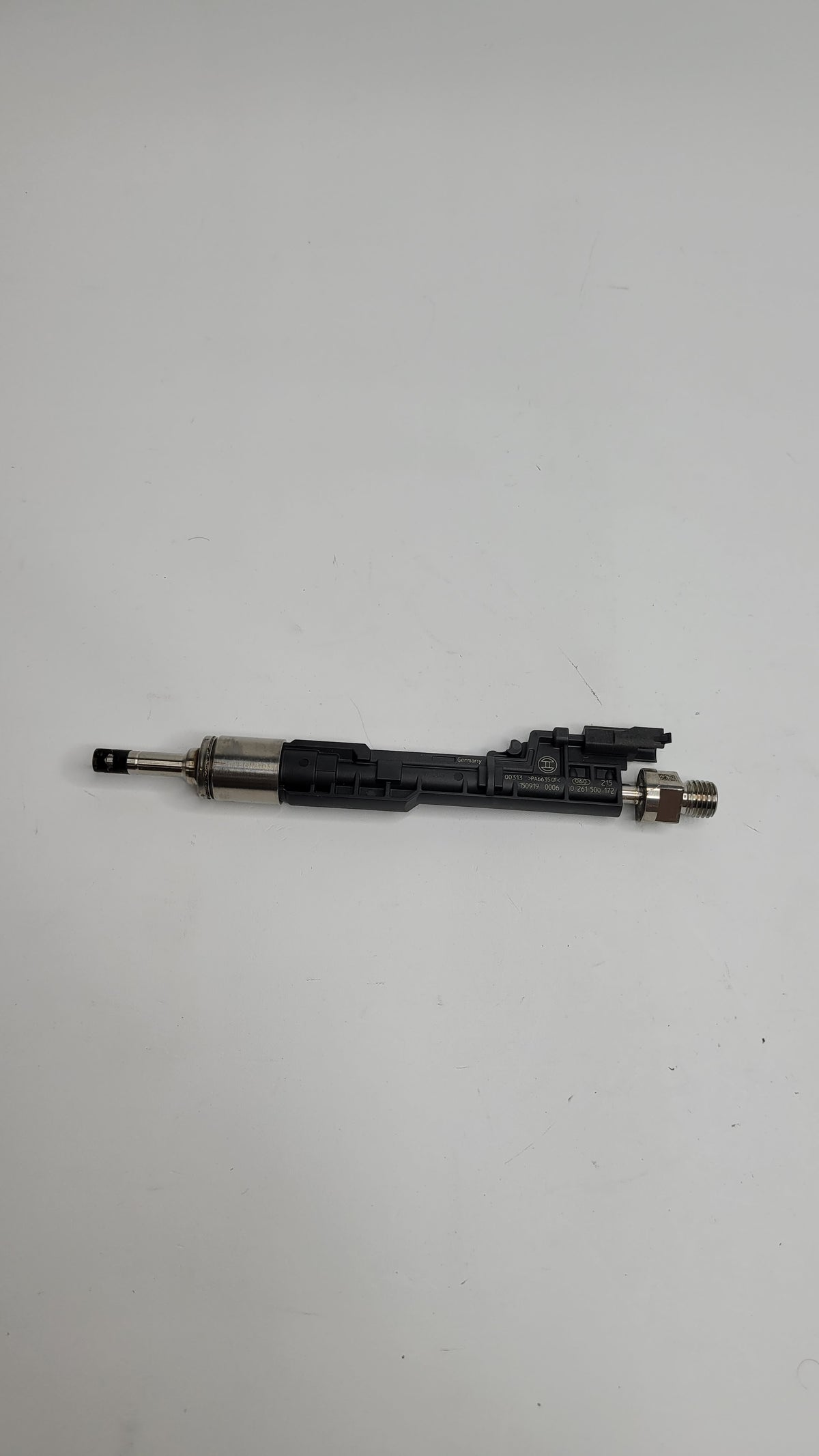 F80 M3 injector by MPerformance.parts, close-up of the fuel injector with metal and plastic components for engine performance.