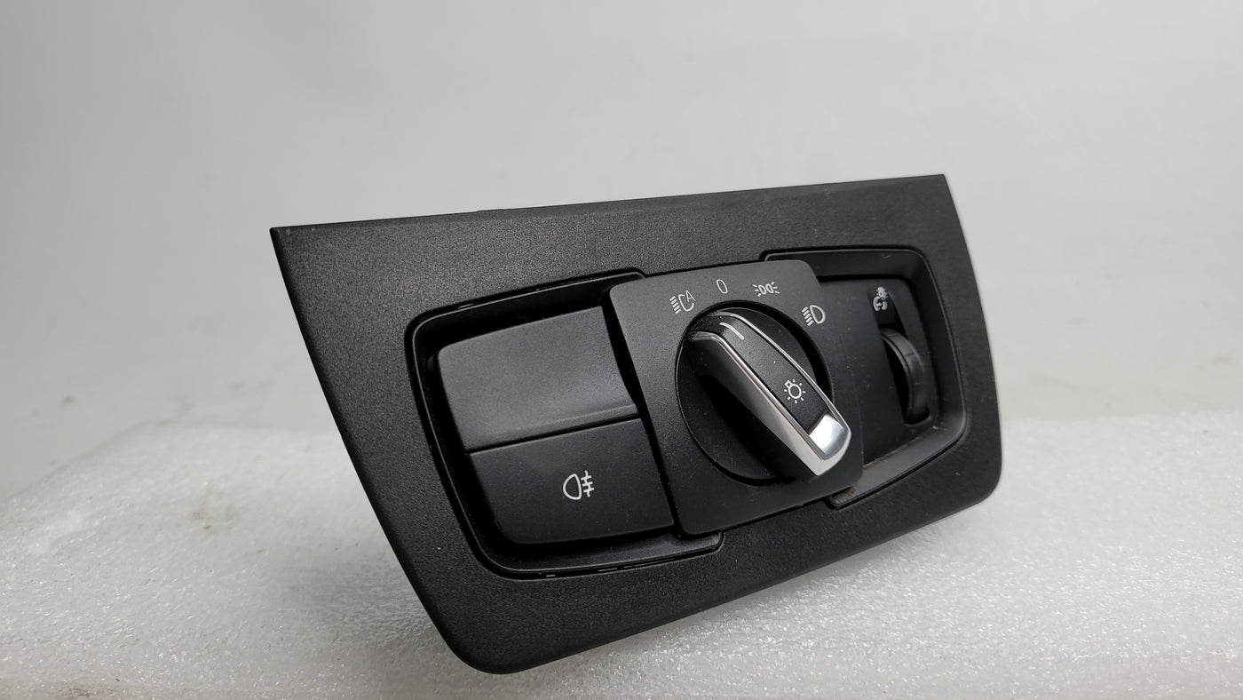 BMW 3 Series F80 headlight control switch with MPerformance.parts branding, showing the switch's buttons and design details.
