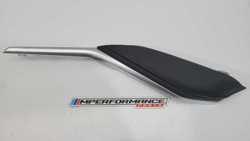 G80 M3 passenger knee leather panel in black, showing textured leather surface with precise stitching and mounting points.